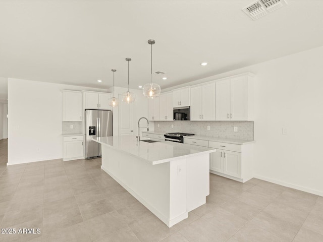 kitchen with a sink, visible vents, white cabinetry, appliances with stainless steel finishes, and a large island