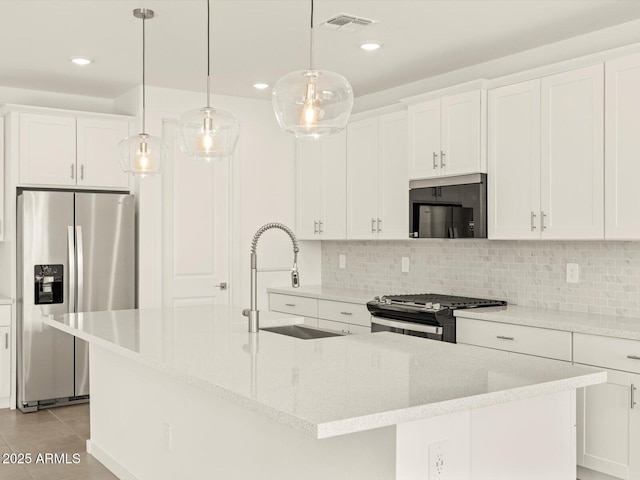 kitchen with visible vents, appliances with stainless steel finishes, backsplash, and a sink