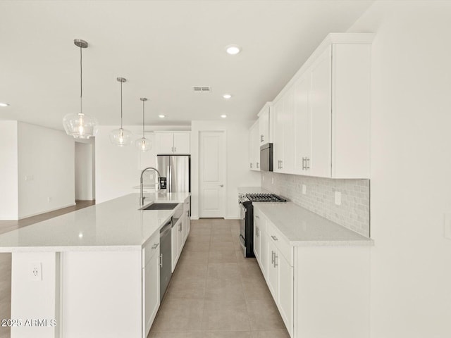 kitchen featuring recessed lighting, stainless steel appliances, a sink, white cabinetry, and decorative backsplash