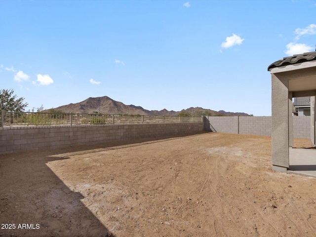 view of yard with a fenced backyard and a mountain view