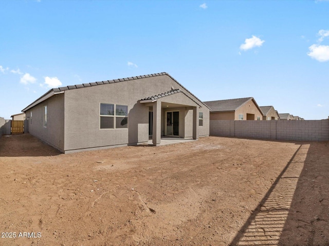 back of property with a patio area, a fenced backyard, a tile roof, and stucco siding