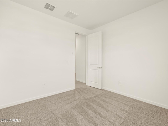 spare room featuring carpet and baseboards