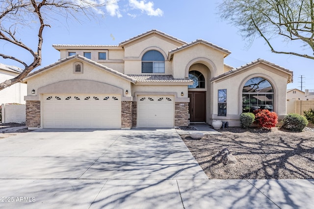 mediterranean / spanish-style home with stone siding, driveway, a tiled roof, and stucco siding