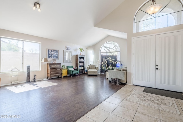 entrance foyer with high vaulted ceiling and wood finished floors