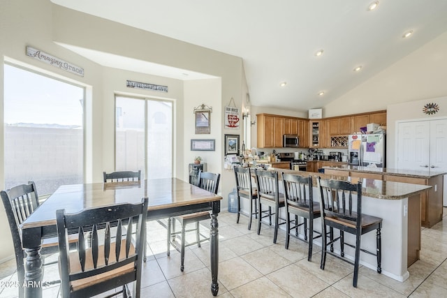 dining space featuring recessed lighting, vaulted ceiling, and light tile patterned floors