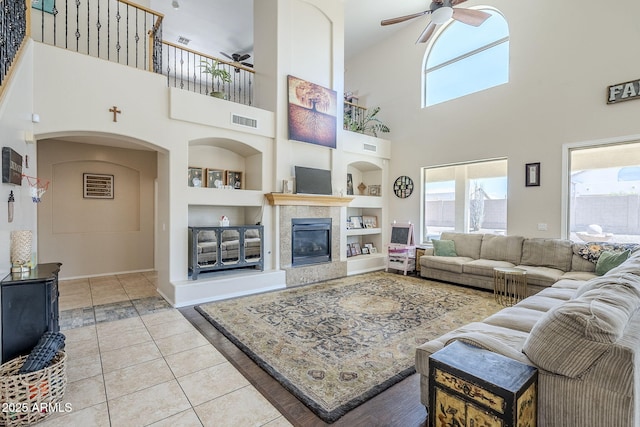 living area with light tile patterned floors, a wealth of natural light, visible vents, and built in features