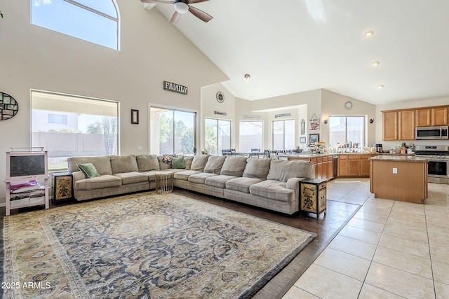 living room featuring light tile patterned floors, lofted ceiling, and a ceiling fan