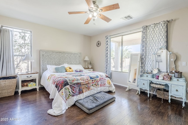 bedroom with a ceiling fan, baseboards, visible vents, and wood finished floors