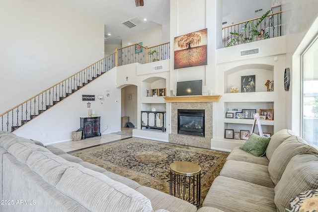 living room with baseboards, visible vents, and built in features