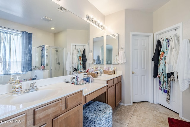 full bathroom with vanity, a stall shower, tile patterned flooring, and visible vents