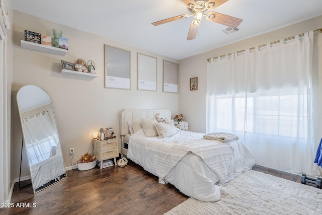 bedroom with ceiling fan, dark wood-type flooring, multiple windows, and visible vents