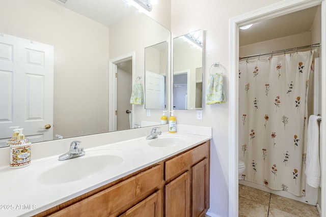 bathroom with tile patterned flooring, a sink, toilet, and double vanity