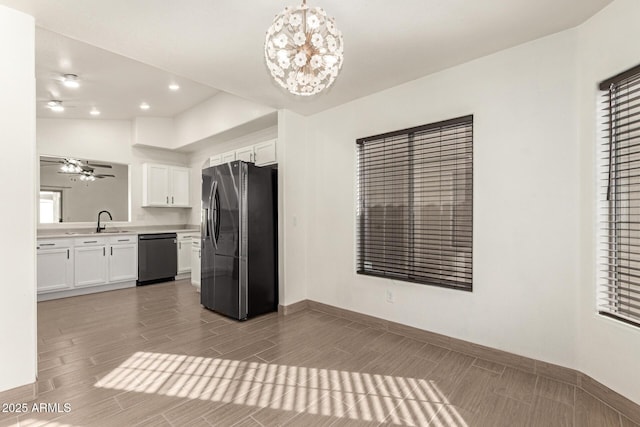 kitchen featuring ceiling fan with notable chandelier, white cabinets, decorative light fixtures, black dishwasher, and fridge with ice dispenser