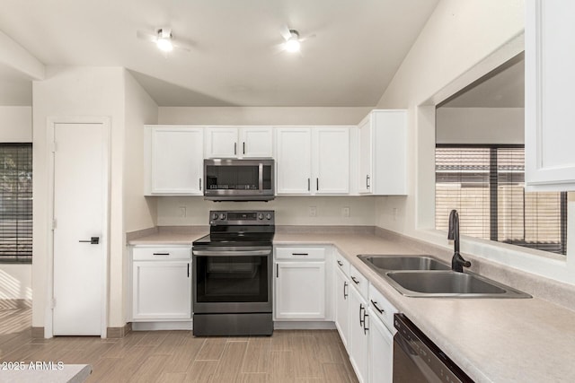 kitchen featuring stainless steel appliances, white cabinetry, and sink