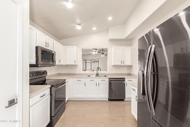 kitchen featuring white cabinetry, stainless steel appliances, sink, vaulted ceiling, and ceiling fan