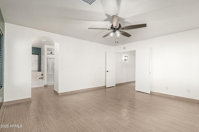 empty room featuring light wood-type flooring, ceiling fan, and a textured ceiling