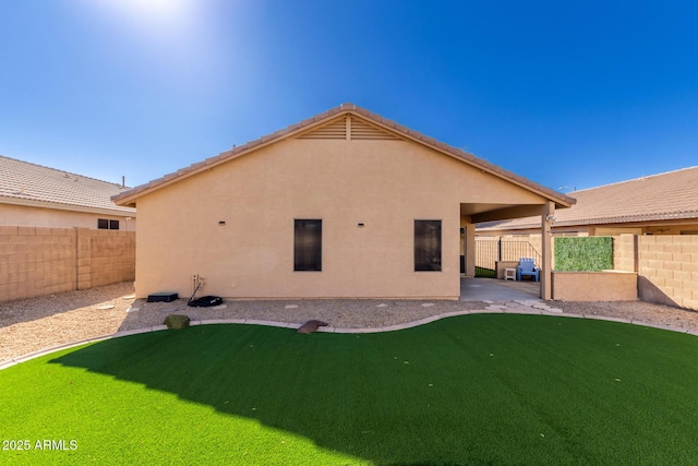 back of property with a lawn and a patio area