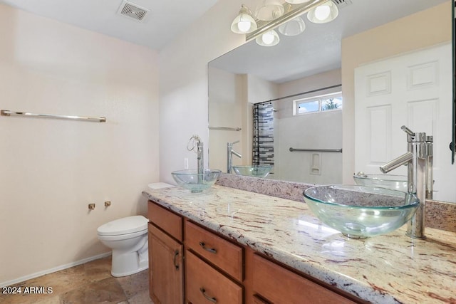 bathroom featuring vanity, toilet, and walk in shower