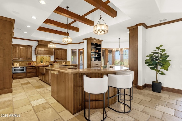 14760 E Paradise Dr, Fountain Hills, AZ 85268 - kitchen with custom exhaust hood, stone tile flooring, backsplash, a breakfast bar area, and recessed lighting