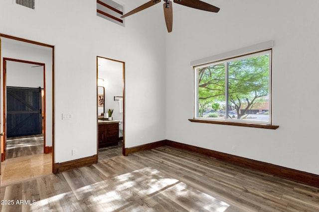 14760 E Paradise Dr, Fountain Hills, AZ 85268 - unfurnished bedroom with wood finished floors, baseboards, a high ceiling, and connected bathroom