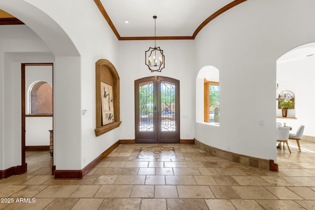 14760 E Paradise Dr, Fountain Hills, AZ 85268 - entryway with stone tile flooring, baseboards, a chandelier, crown molding, and a high ceiling