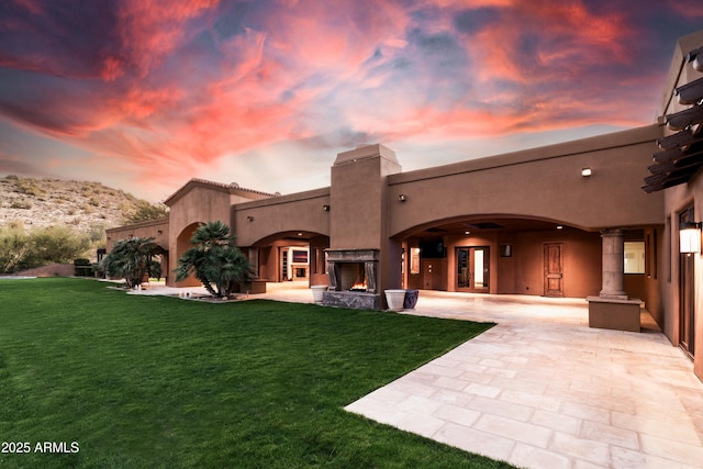 14760 E Paradise Dr, Fountain Hills, AZ 85268 - back of house at dusk with stucco siding, a yard, a chimney, and a patio