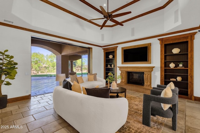 14760 E Paradise Dr, Fountain Hills, AZ 85268 - living room with built in features, a glass covered fireplace, a ceiling fan, a towering ceiling, and stone tile flooring