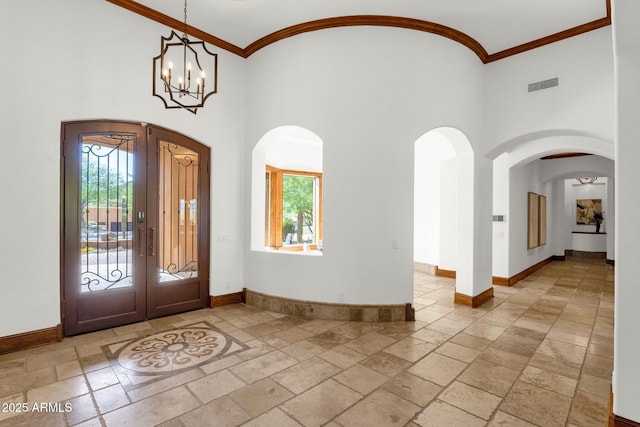 14760 E Paradise Dr, Fountain Hills, AZ 85268 - foyer featuring stone tile floors, arched walkways, plenty of natural light, a towering ceiling, and crown molding