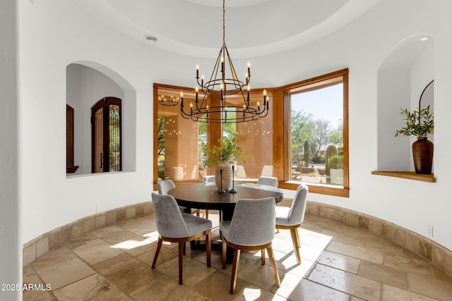 14760 E Paradise Dr, Fountain Hills, AZ 85268 - dining space featuring stone tile flooring, a chandelier, arched walkways, and baseboards