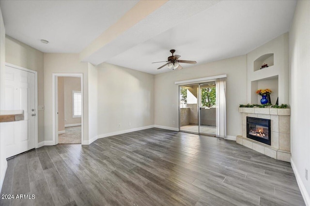 unfurnished living room featuring hardwood / wood-style flooring, ceiling fan, and a tile fireplace