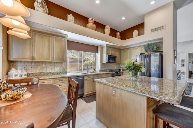 kitchen with sink, decorative backsplash, stainless steel appliances, and light stone countertops