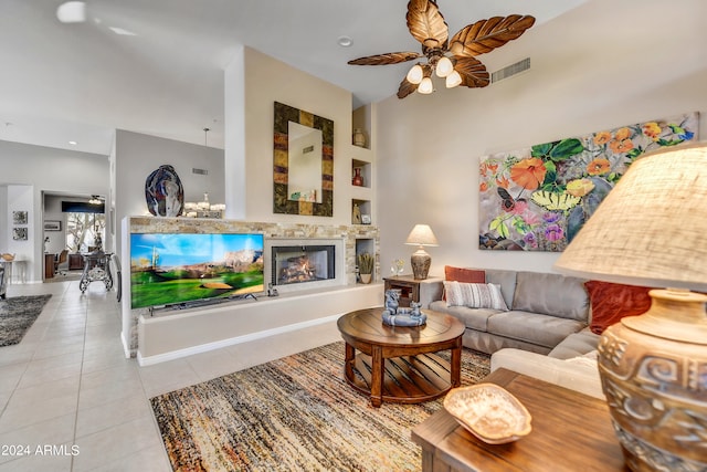 living room featuring built in shelves, ceiling fan, and light tile patterned flooring