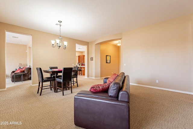 dining space featuring a chandelier, light carpet, and baseboards