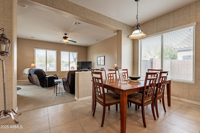 dining area featuring light tile patterned floors, a ceiling fan, visible vents, and baseboards