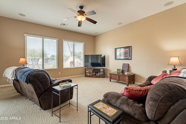 living room with light carpet, baseboards, visible vents, and ceiling fan