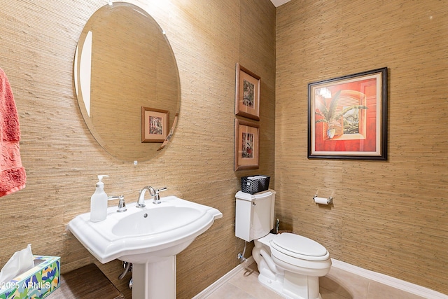 bathroom with toilet, tile patterned flooring, and baseboards