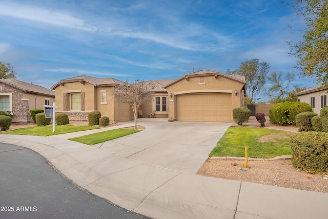 mediterranean / spanish-style home with a garage, a tiled roof, concrete driveway, and stucco siding