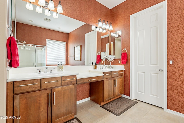 bathroom with double vanity, a stall shower, baseboards, visible vents, and a sink