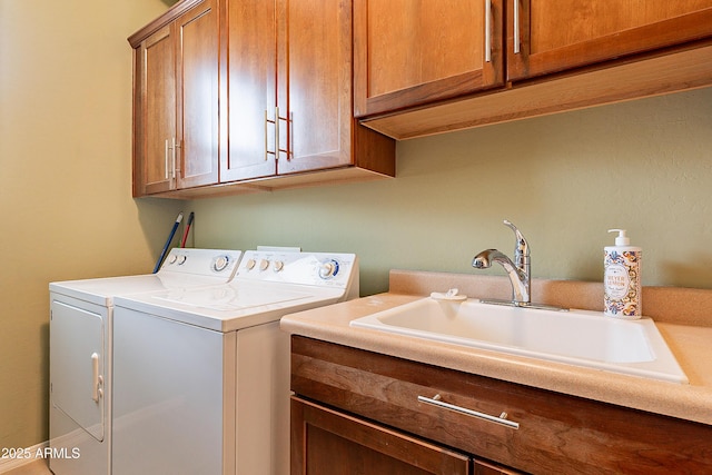 washroom featuring washing machine and dryer, cabinet space, and a sink