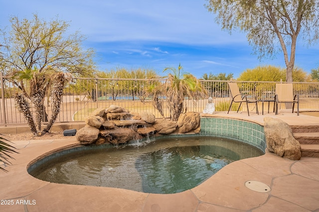 view of swimming pool featuring fence and a hot tub