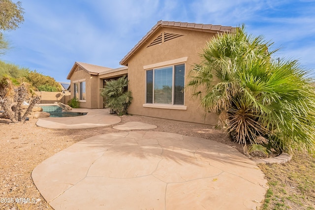 back of house featuring a fenced in pool, fence, a patio, and stucco siding