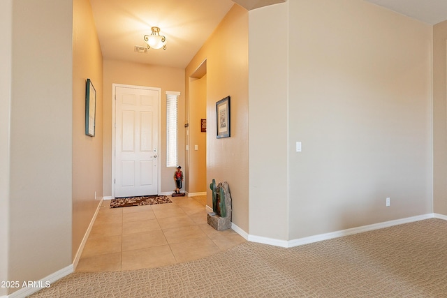 interior space featuring light tile patterned floors, light colored carpet, and baseboards