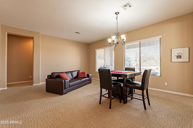 dining area featuring light colored carpet, a notable chandelier, and visible vents