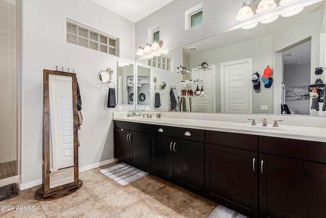 bathroom featuring tiled shower, vanity, and tile patterned floors