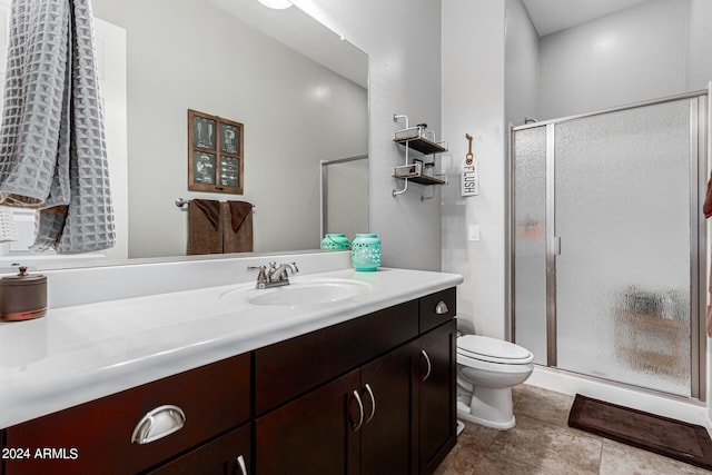 bathroom featuring tile patterned floors, a shower with shower door, vanity, and toilet