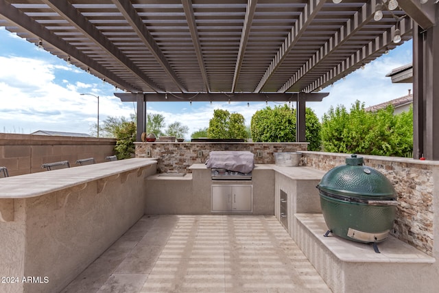 view of patio / terrace featuring a pergola, a grill, and exterior kitchen