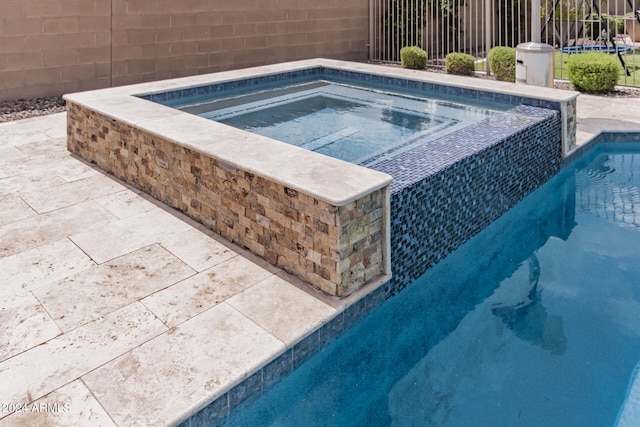 view of pool with an in ground hot tub