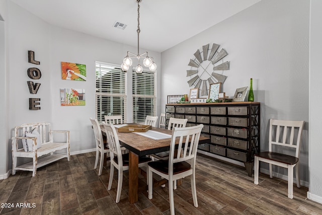 dining space featuring dark wood-type flooring and an inviting chandelier