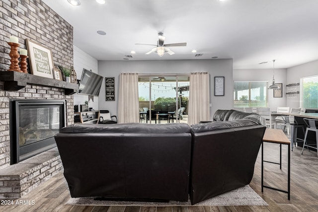 living room featuring ceiling fan, a fireplace, and hardwood / wood-style floors