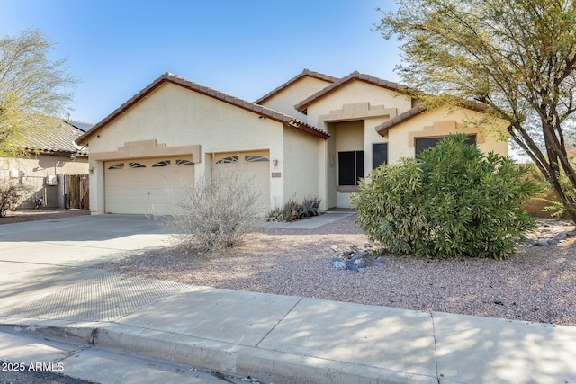 mediterranean / spanish home with driveway, stucco siding, a tiled roof, and an attached garage